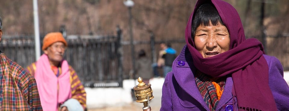 Bhutan Lady with a prayer wheel